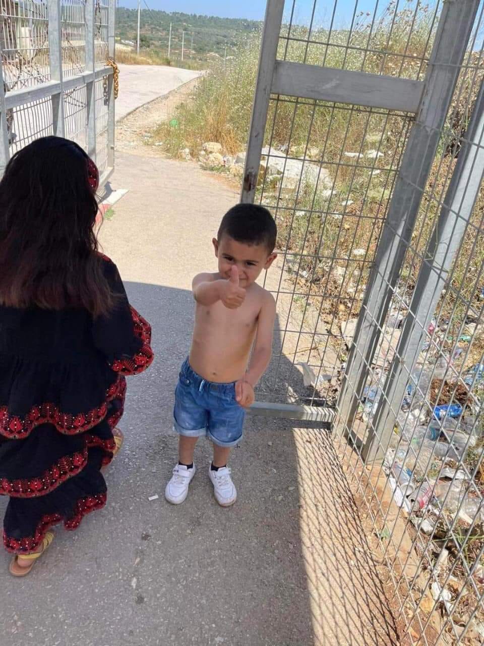 الطفل يوسف رافعًا شارة النصر، بعد أن أجبره جنود الاحتلال على خلع قميص عليه صورة بندقية