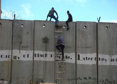 فلسطينيون من الضفة يتسلّقون الجدار الإسرائيليّ الفاصل للوصول إلى القدس، والصلاة في المسجد الأقصى (عصام الريماوي - Getty - 2019) 