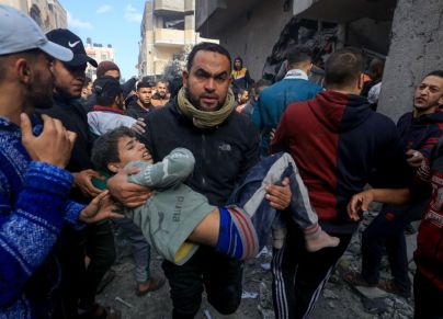 رجل يحمل طفلاً أصيب في قصف إسرائيلي على رفح في جنوب قطاع غزة في 20 نوفمبر 2023، تصوير محمود حمص 