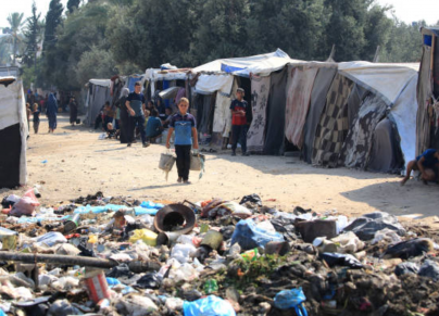 أكوام من النفايات المتكدّسة وسط النازحين في دير البلح وسط قطاع غزة (getty) 