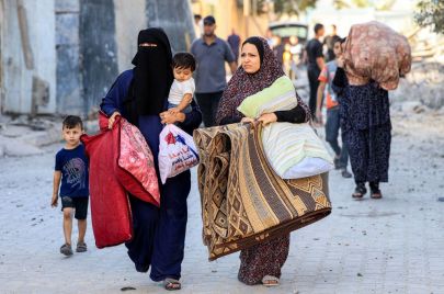 نساء فلسطينيات مع أطفالهن أثناء فرارهن من منطقة ما في أعقاب غارة جوية على رفح. تصوير سعيد خطيب