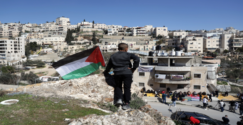 طفل يرفع علم فلسطين قبالة البناية المهددة بالهدم في حي واد قدوم في سلوان | تصوير سعيد القاق