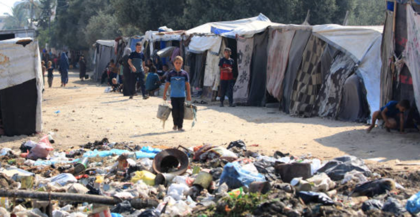 أكوام من النفايات المتكدّسة وسط النازحين في دير البلح وسط قطاع غزة (getty) 