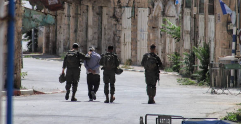 جنود إسرائيليون يعتقلون فلسطينيًا في الخليل (getty)