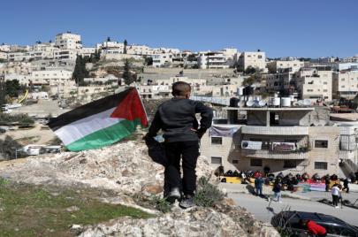 طفل يرفع علم فلسطين قبالة البناية المهددة بالهدم في حي واد قدوم في سلوان | تصوير سعيد القاق